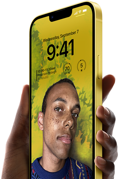 Käsi pitelee keltaista iPhone 14 Plussaa, jossa näkyy personoitu lukittu näyttö.